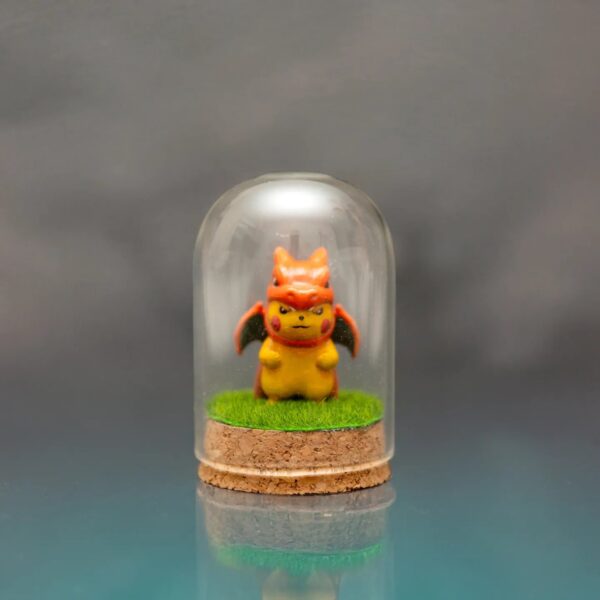 ¡Añade un toque de magia Pokémon a tu colección con esta encantadora figurita de Pikachu disfrazado de Charmander!